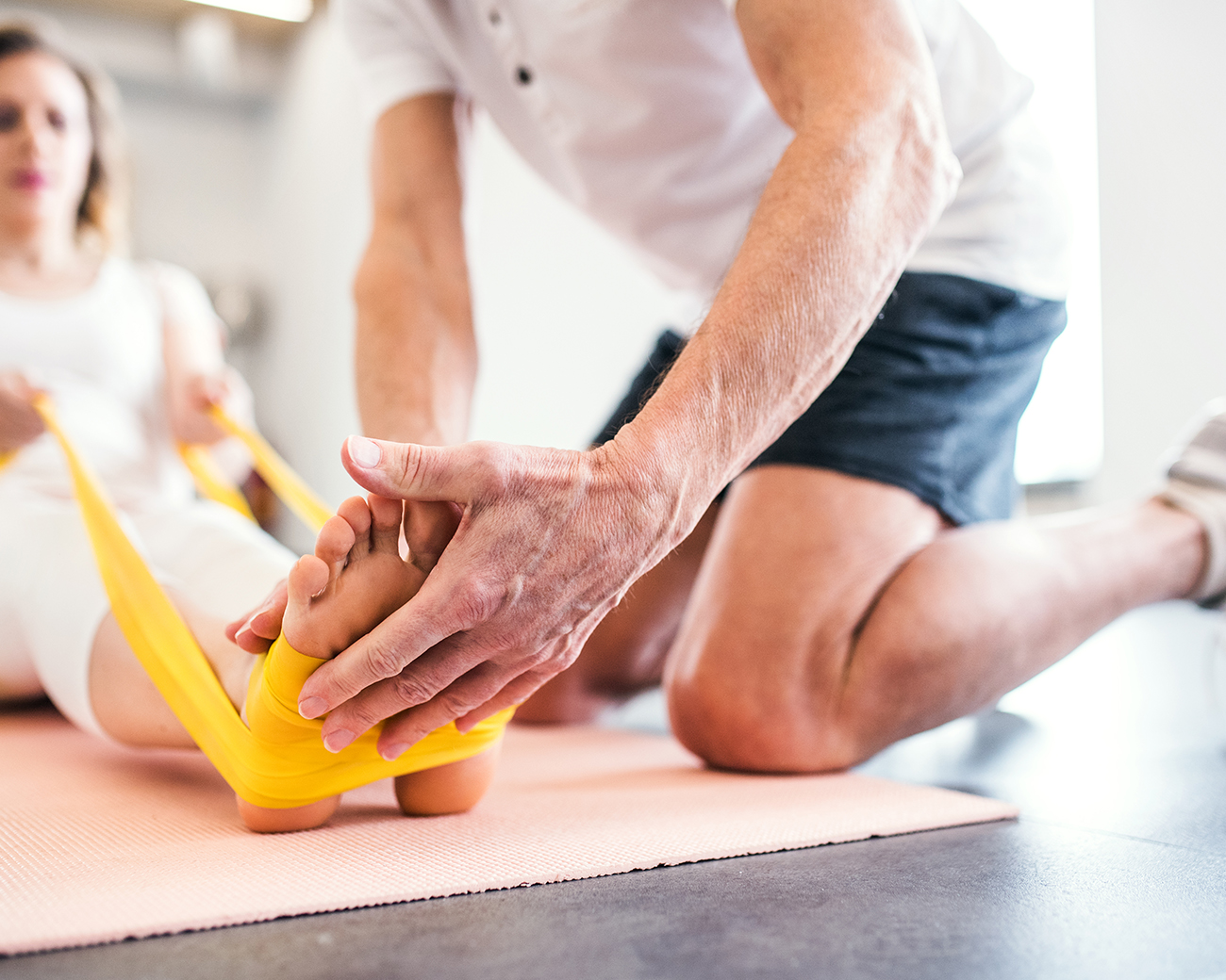 Fysiotherapeut doet oefeningen met cliënt