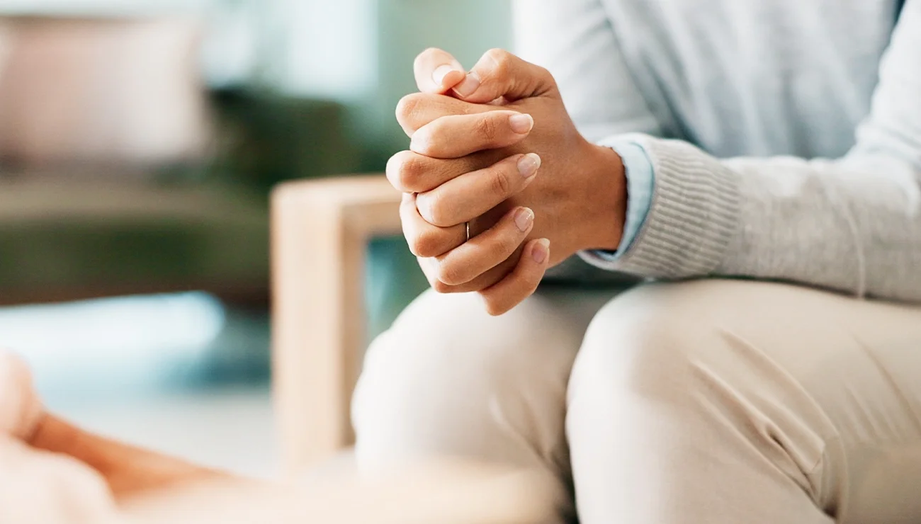 Handen gevouwen op tafel