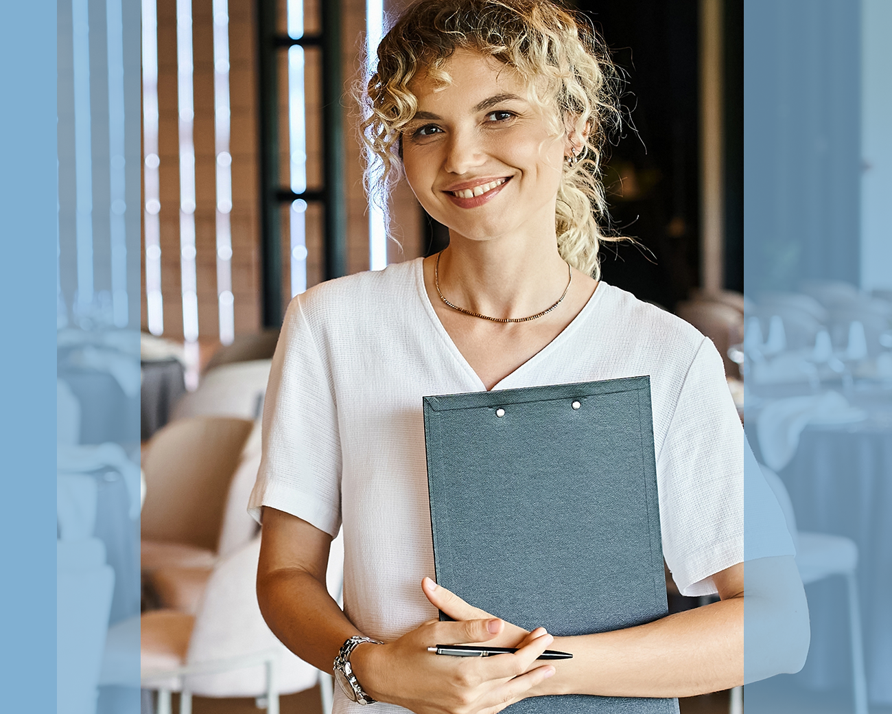 Vrolijke eventmanager met clipboard tijdens voorbereiding event