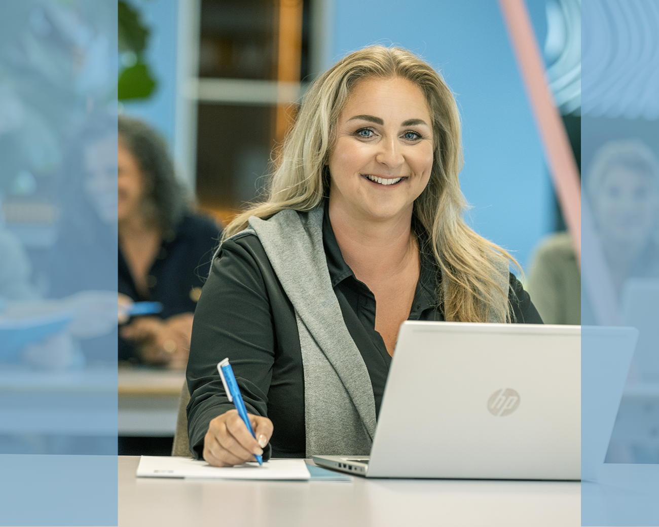 Lachende vrouw met notitieblok en laptop