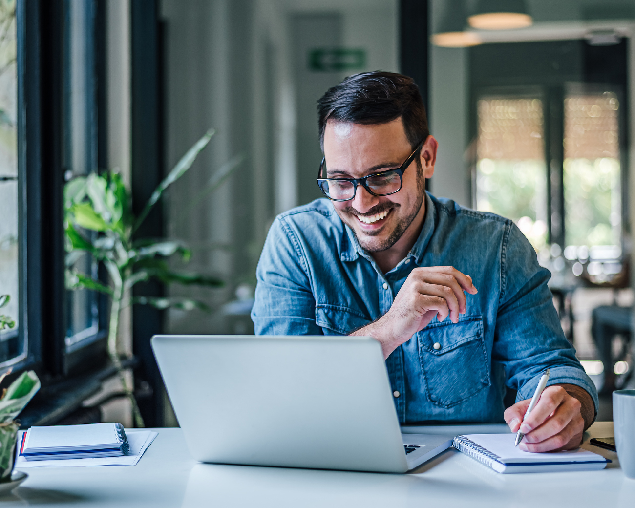 Man lachend achter laptop