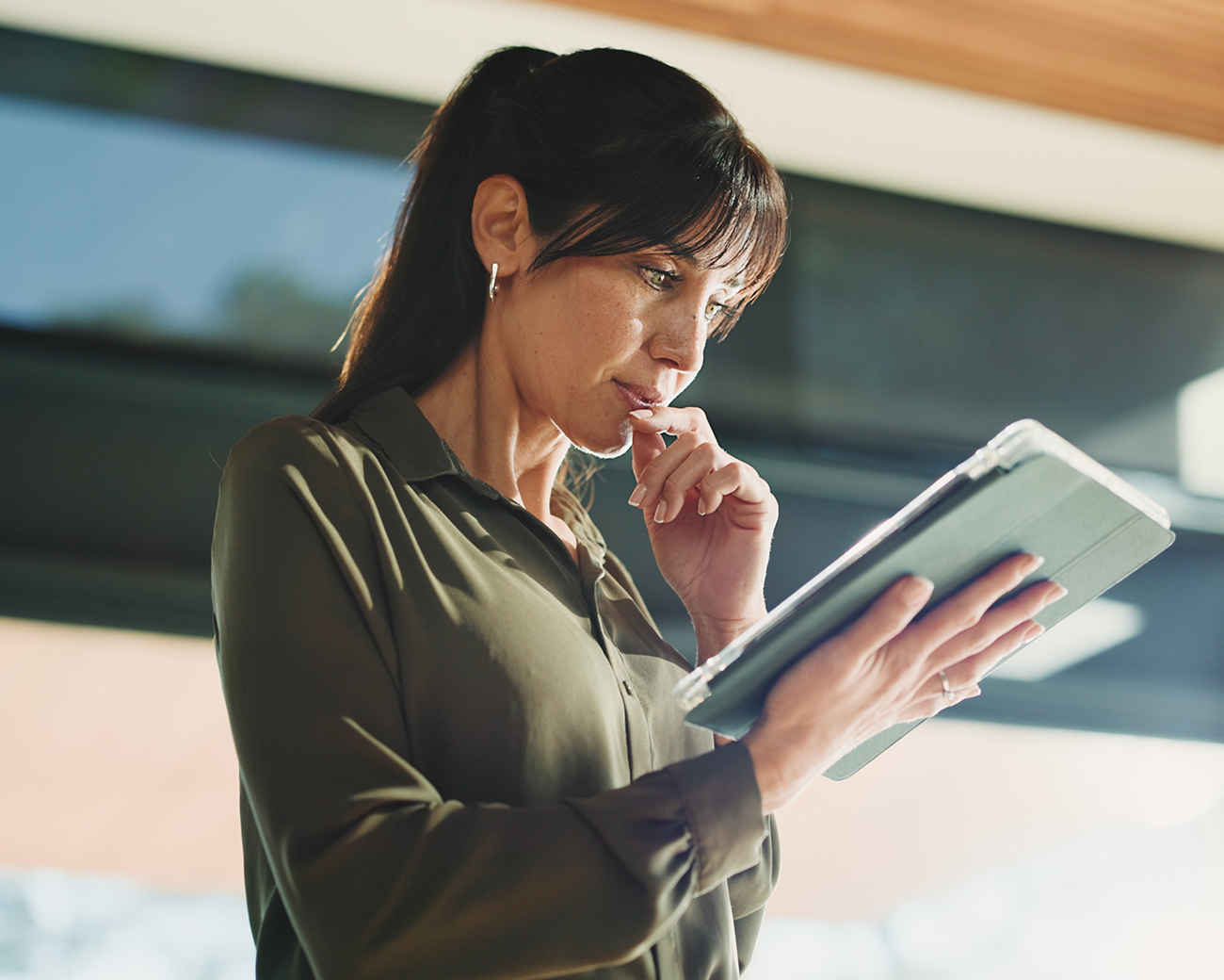 Vrouw kijkt geconcentreerd naar tablet