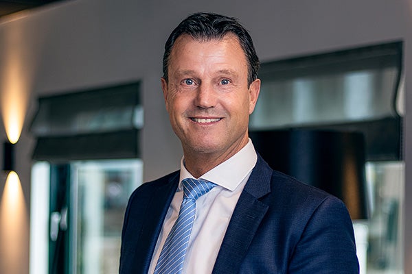 Portretfoto van ISBW-directeur Rob Rijbroek in blauw jasje met blauw gestreepte stropdas.