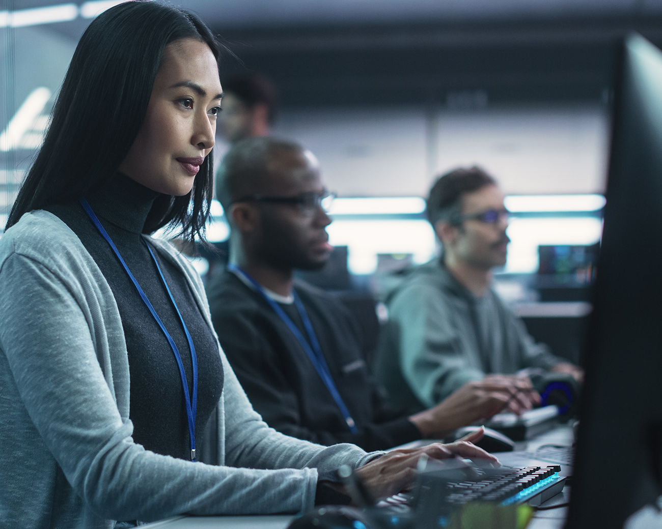 Een vrouw en twee mannen werken op een computer