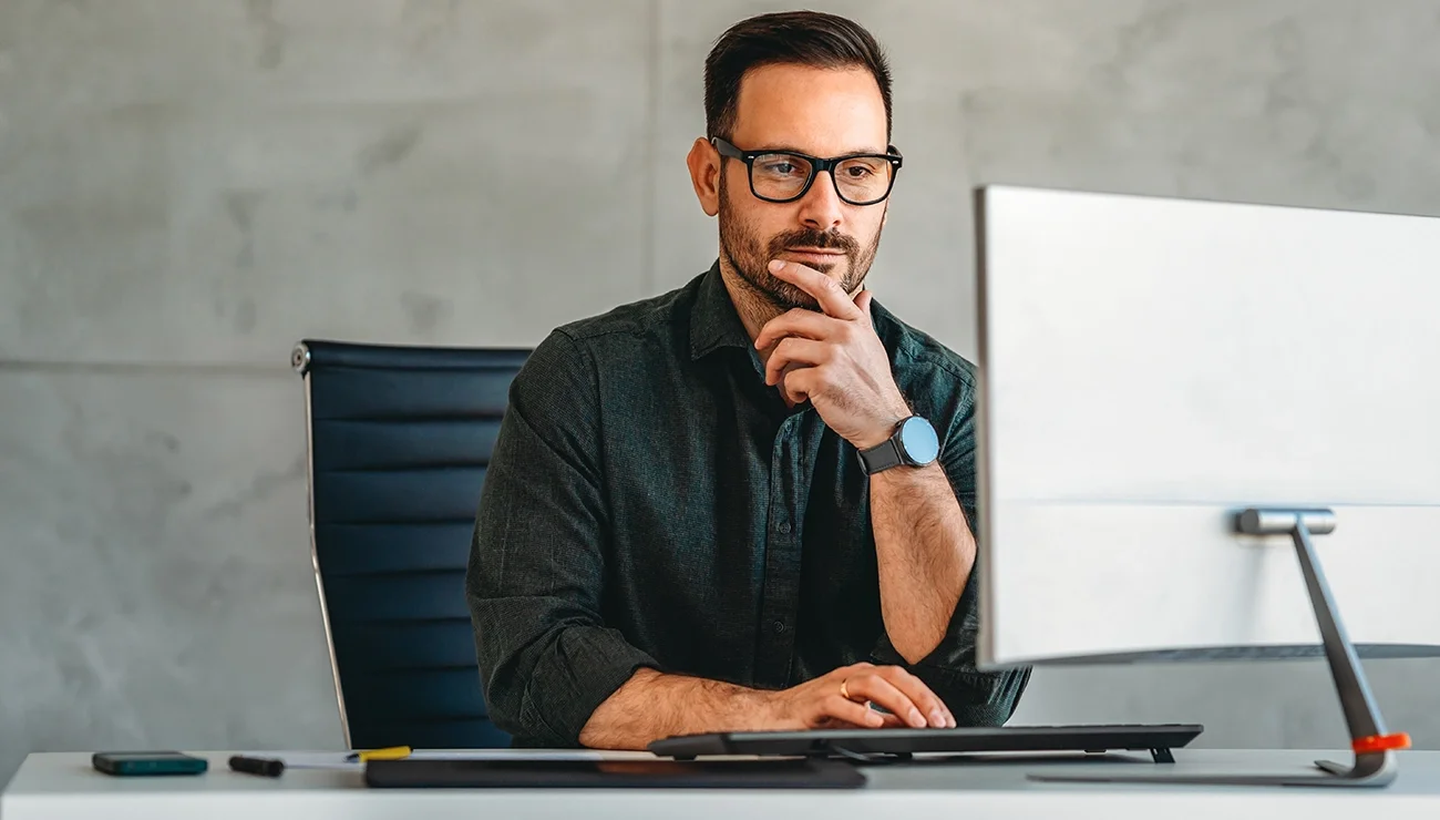 Man kijkt geconsentreerd naar computerscherm