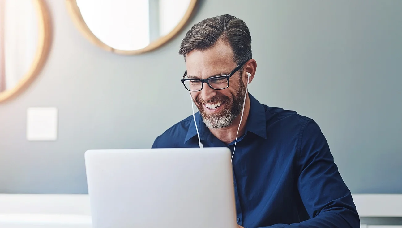 Man met bedrade oordopjes belt via laptop