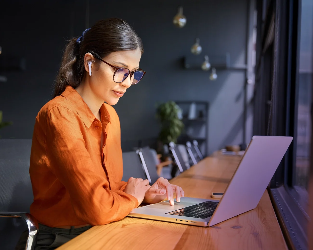 Vrouw werkt achter laptop in kantooromgeving