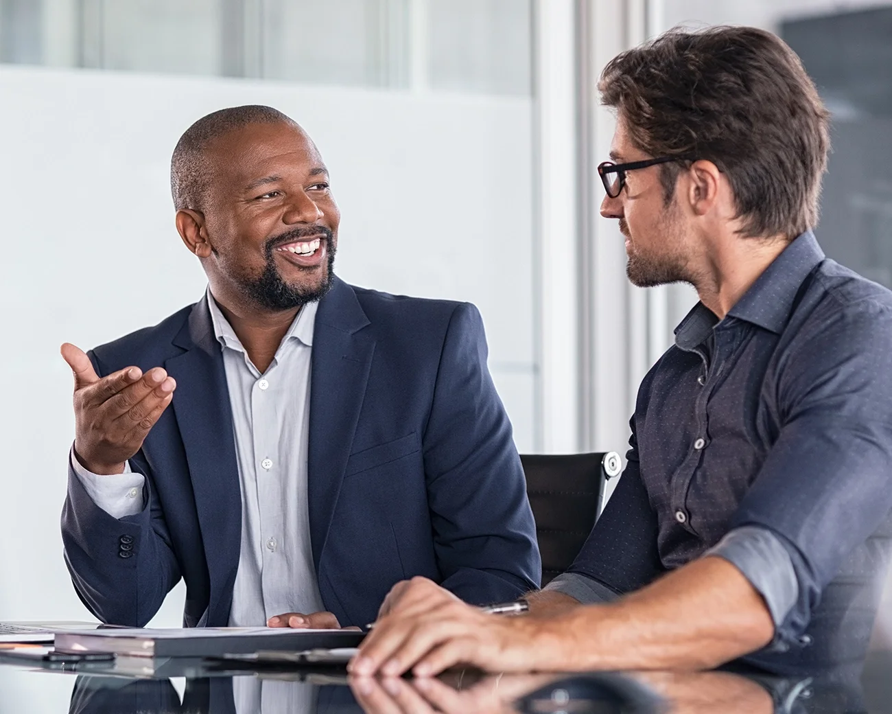 Mannelijke collega's in gesprek aan tafel