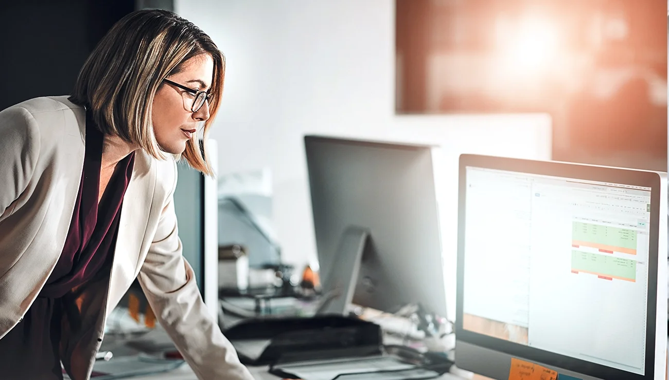 Vrouw kijkt geconcentreerd naar haar computerscherm