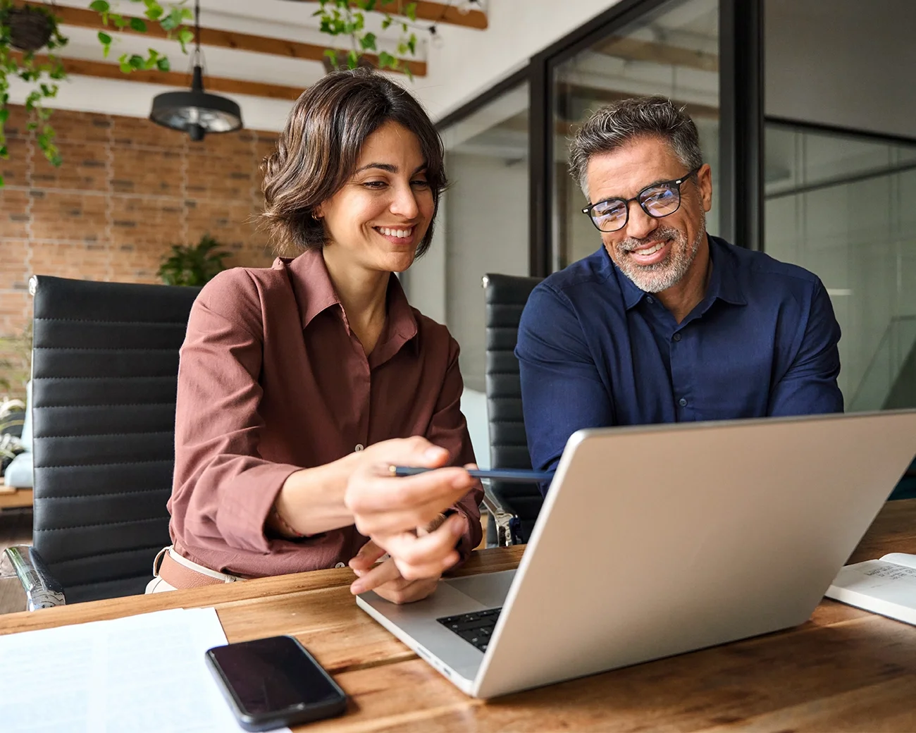 Vrouw en man werken samen achter laptop
