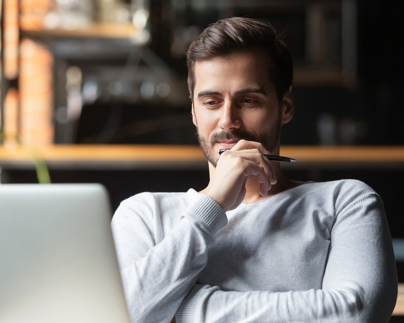 Man kijkt bedenkelijk naar laptopscherm