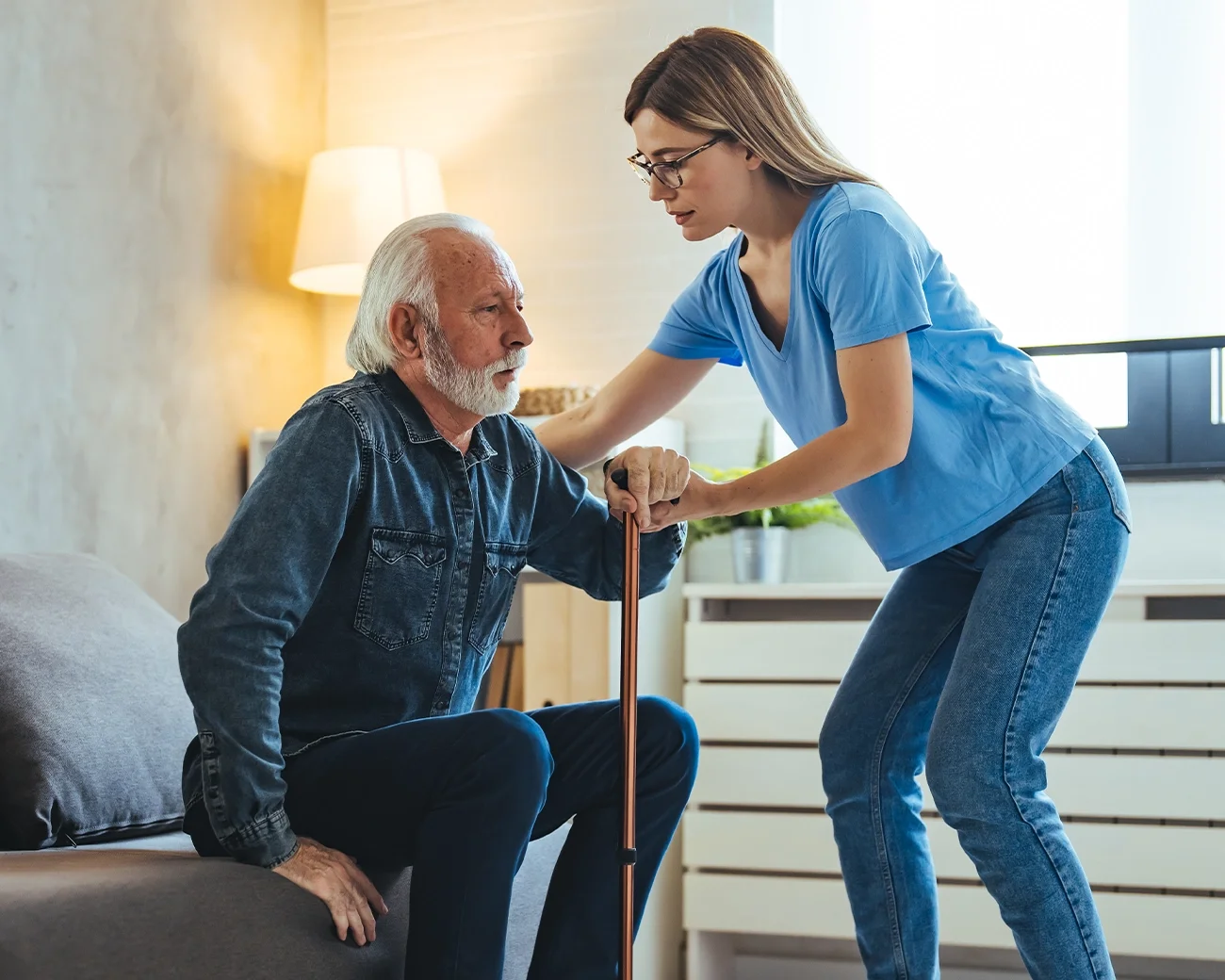 Zorgprofessional helpt oude man met opstaan