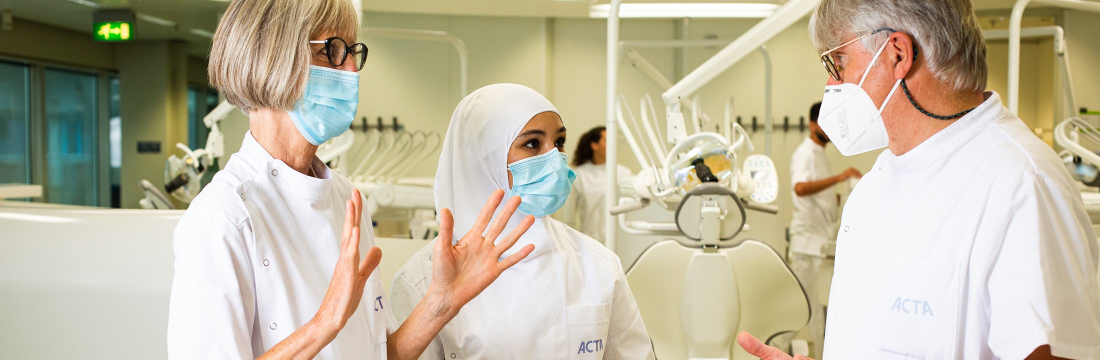 Teachers discuss between the dentist chairs