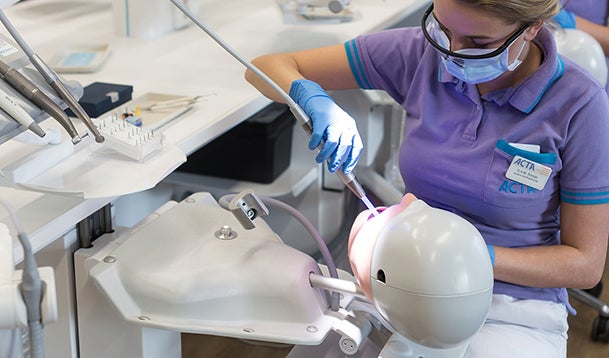 Een Tandheelkunde studente oefent behandelingen uit op een robot