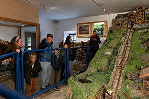 Besucherinnen und Besucher schauen sich die Dauer·ausstellung am Standort Ridnaun an.