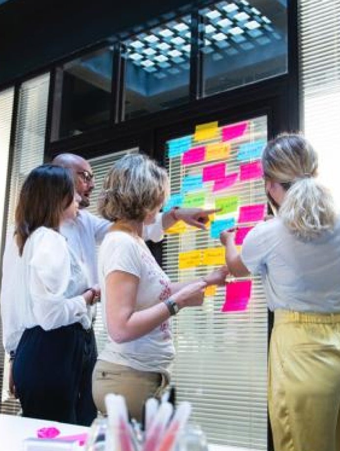 people gather around and strategize with sticky notes