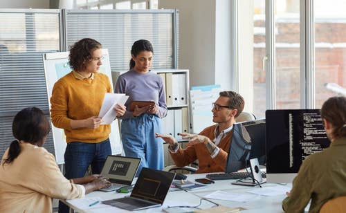 Employees in a bank setting discussing with eachother