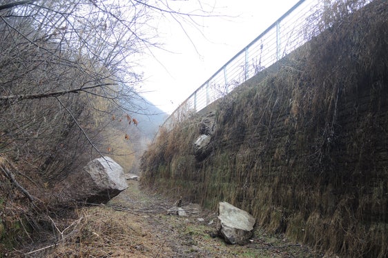 Impatto di un blocco di circa 5 metri cubi sul vallo paramassi a monte della pista ciclabile nella tratta Prato Isarco – Cardano e della strada statale del Brennero poco a Nord dell’uscita A22 “Bolzano Nord”. Il crollo si è verificato il 8 marzo 2018 e mostra come l'altezza del lato monte del tomo-vallo di 6,5 m é ampiamente giustificata.