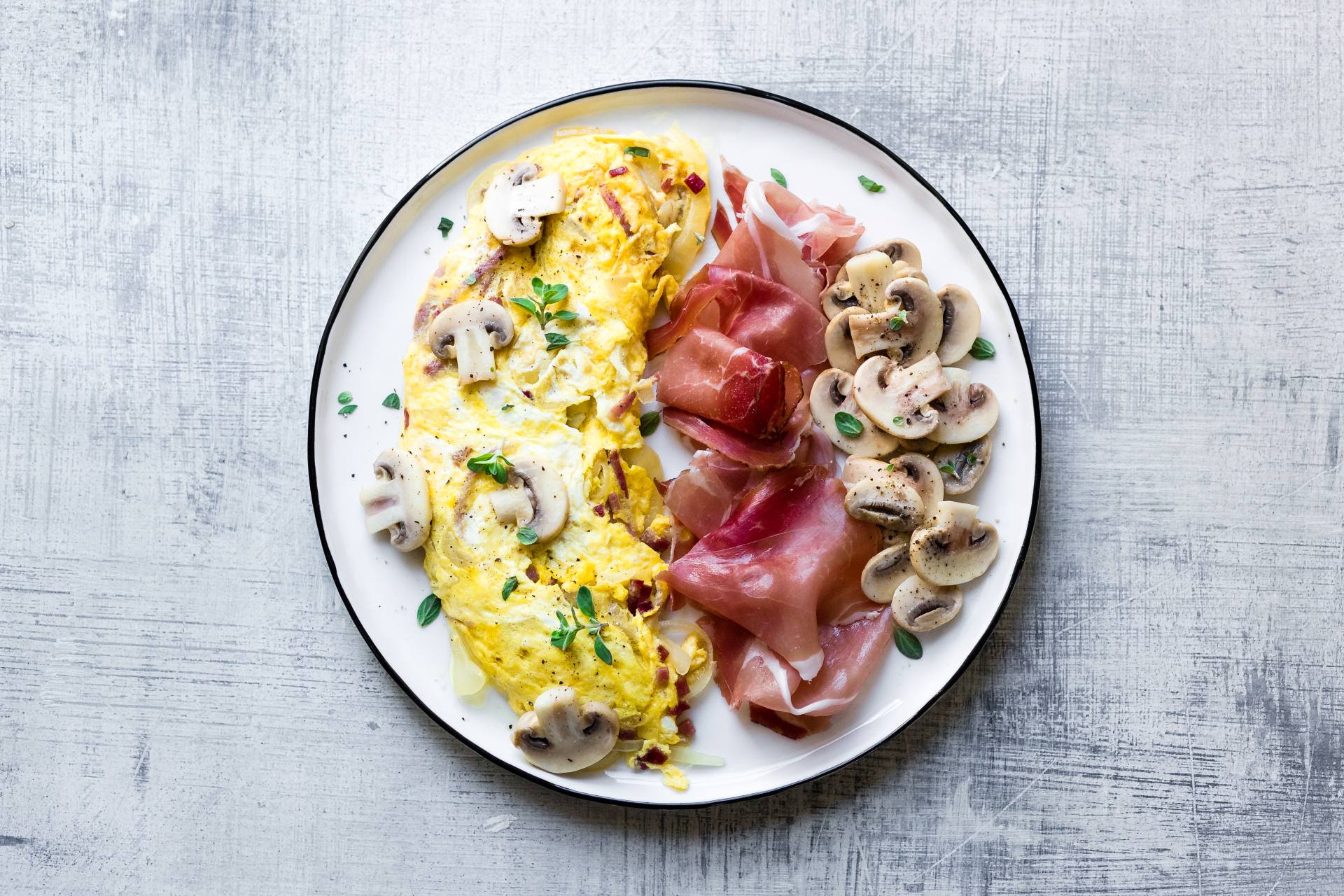 Bauernomelette mit Scheiben von Südtiroler Speck g.g.A. und Champignon-Pilzen.