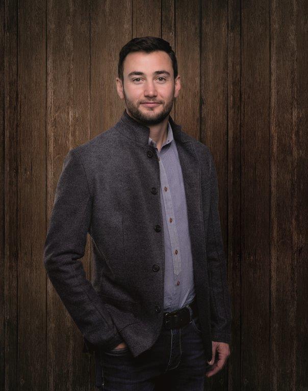 Paul Recla posiert vor Holzwand