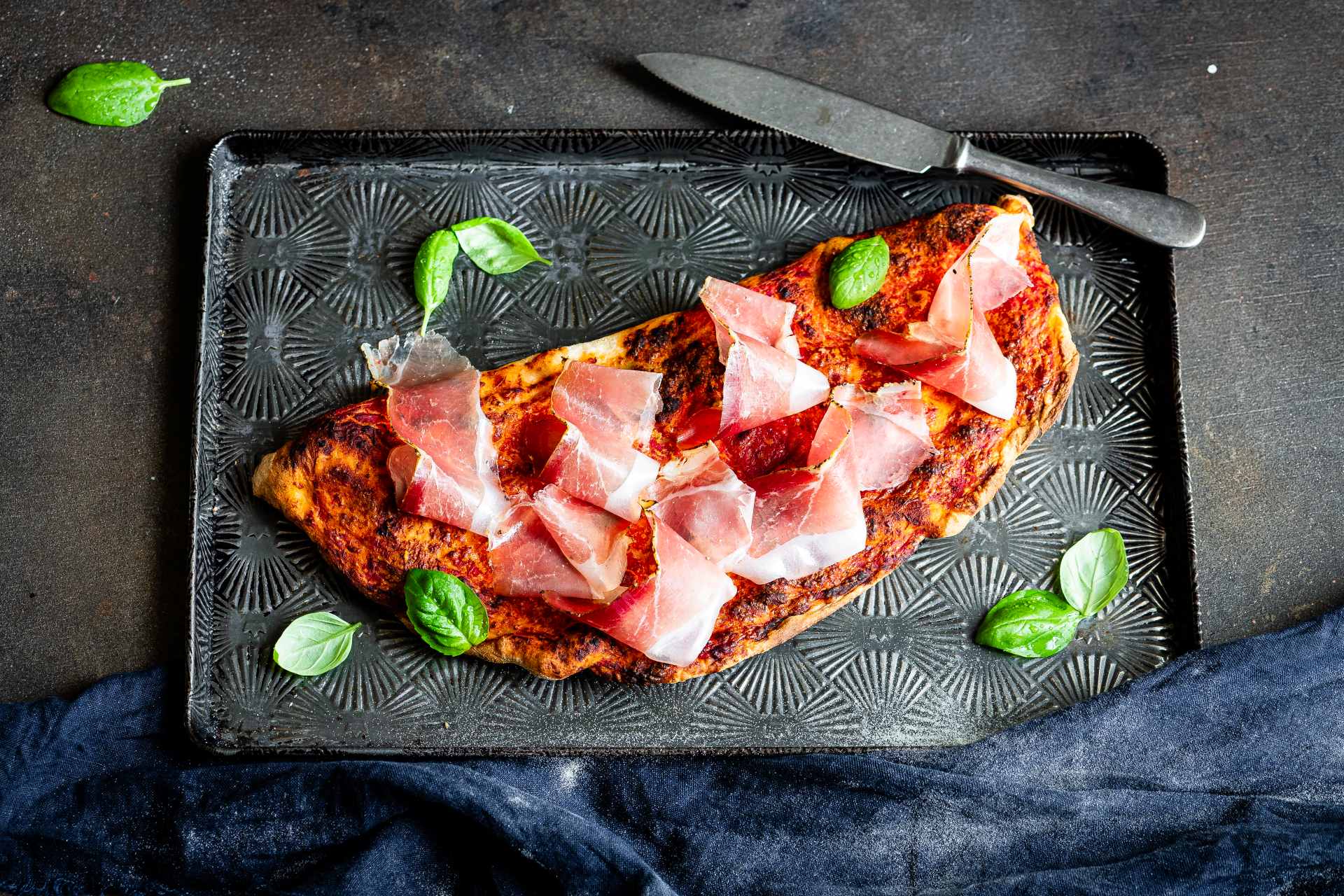 Calzone mit Tomate, Südtiroler Speck g.g.A. und Basilikumblättern.