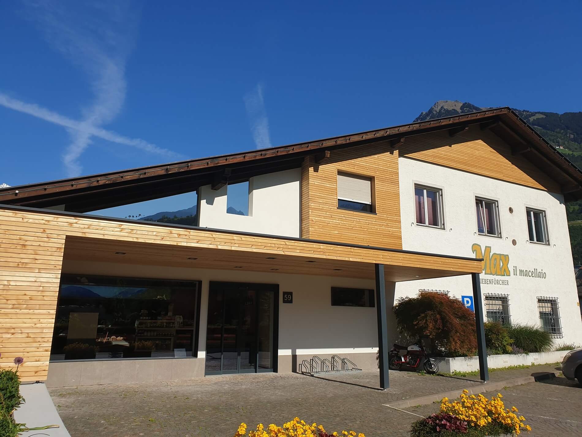 Building of the Max Siebenförcher site with wooden facade, forecourt and entrance