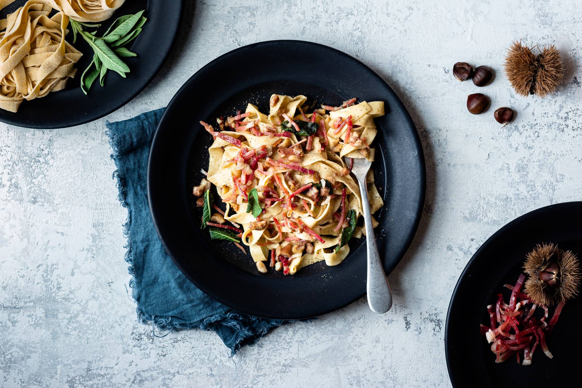 Tagliatelle mit knusprigem Südtiroler Speck g.g.A. und Kastanien, serviert mit Salbeiblättern