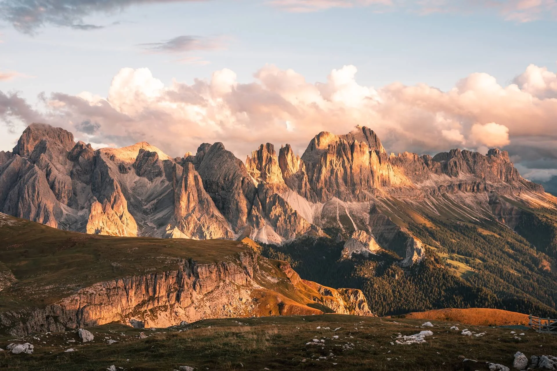 Berglandschaft in Südtirol mit felsigen Gipfeln und Almwiesen im warmen Abendlicht.