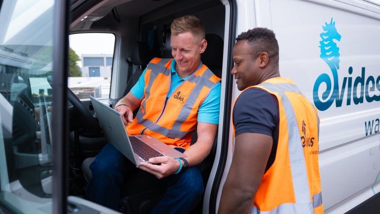 Monteurs kijken op laptop in Evides bus