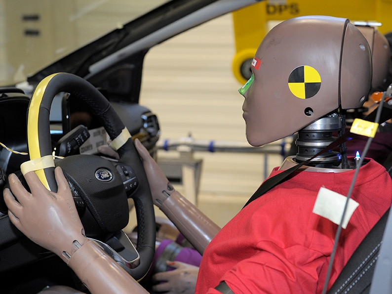 crash test dummy in driver's seat of car