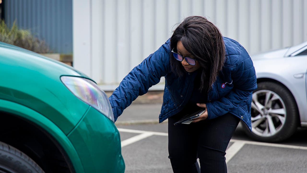 Motorpoint sales executive inspects a trade-in car