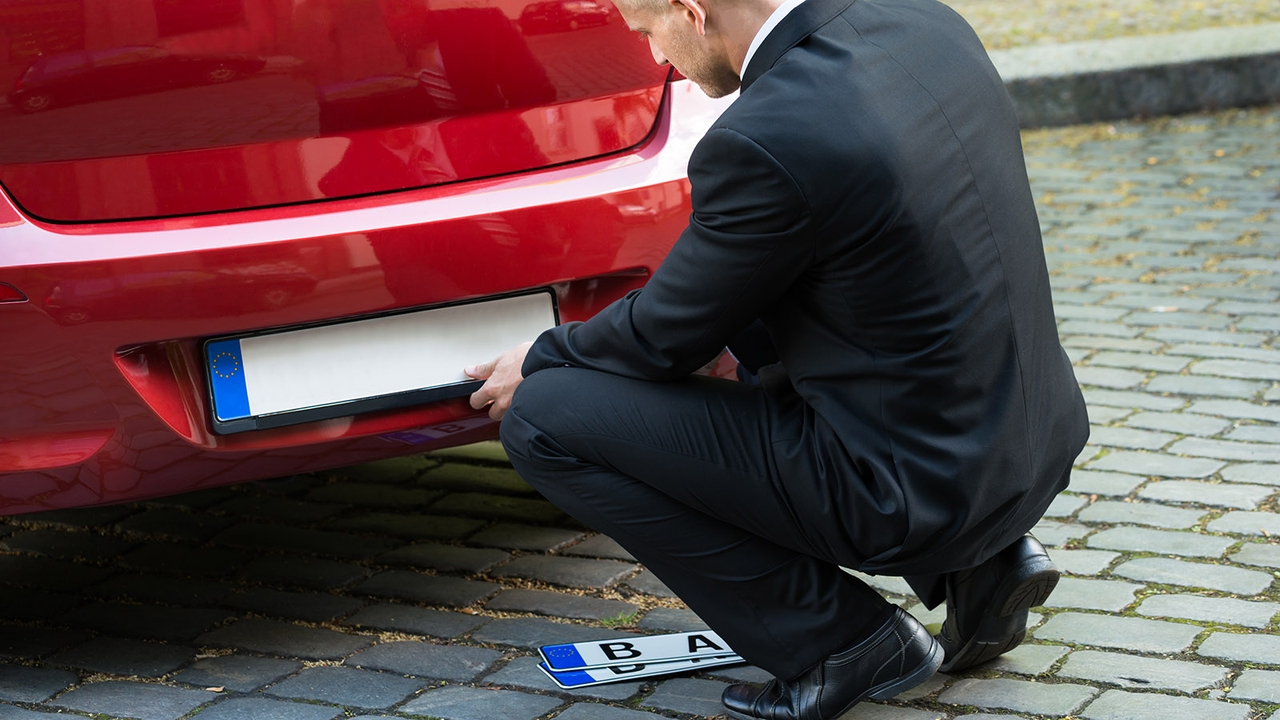 Man changing number plate