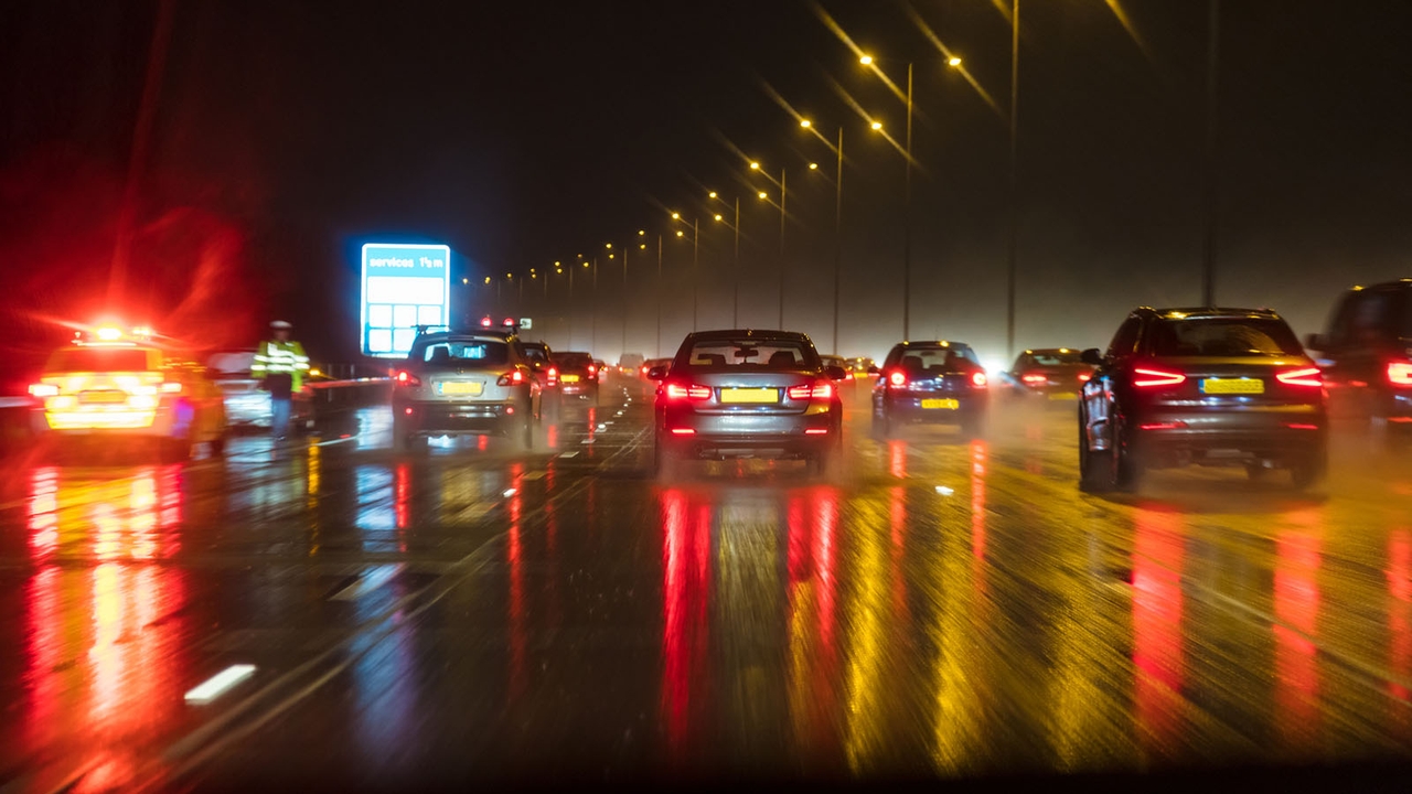 Rainy UK motorway with traffic and a police car