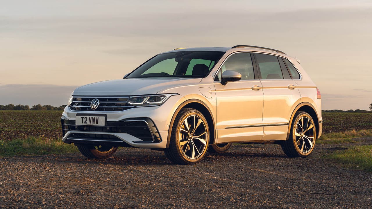 A white VW Tiguan illuminated by an orange sunset