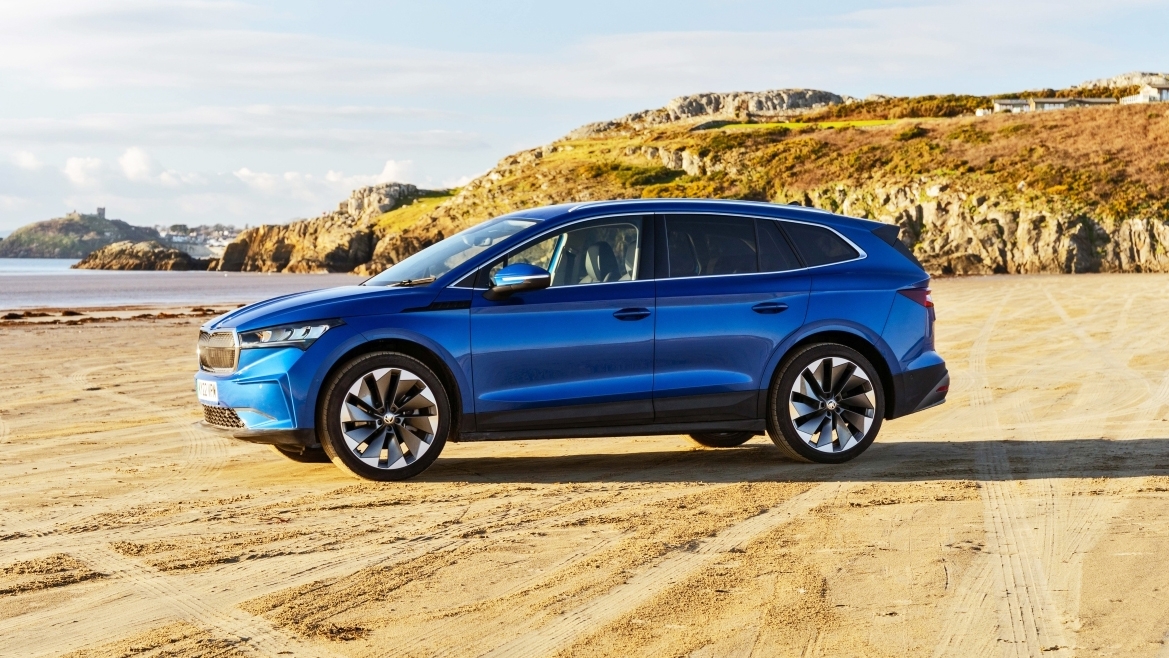 Skoda Enyaq parked on beach – side view