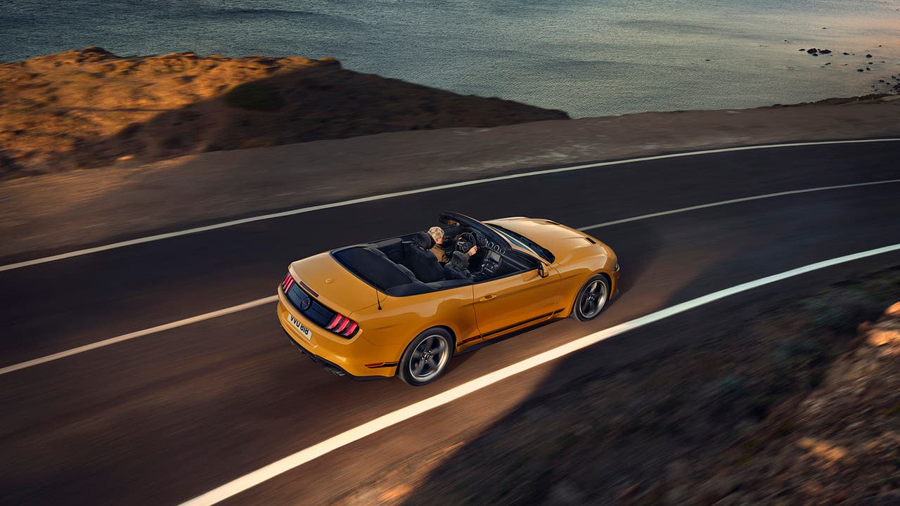 Ford Mustang Convertible in yellow, driving shot