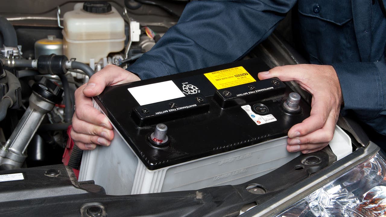 Car battery being pulled out an engine bay