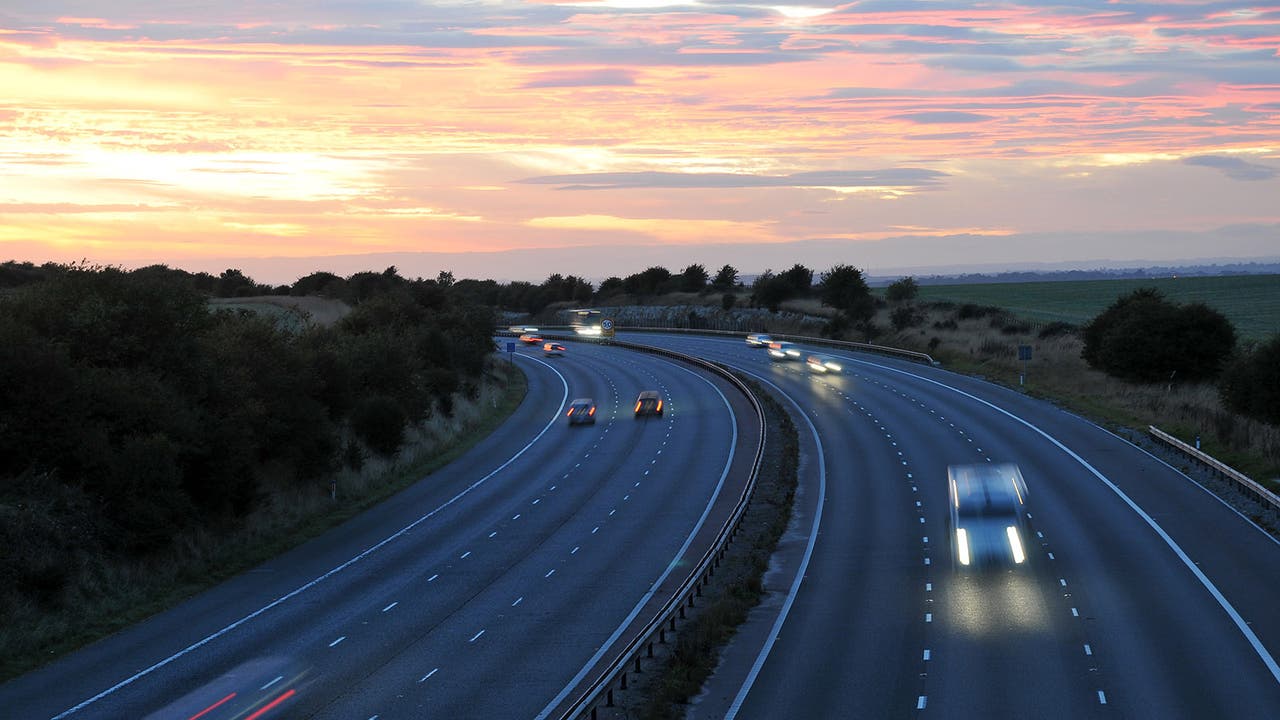 UK motorway at dusk. There is light traffic.
