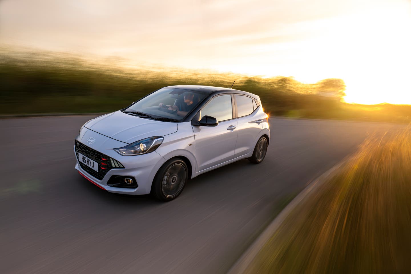 Hyundai i10 driving away from a sunset