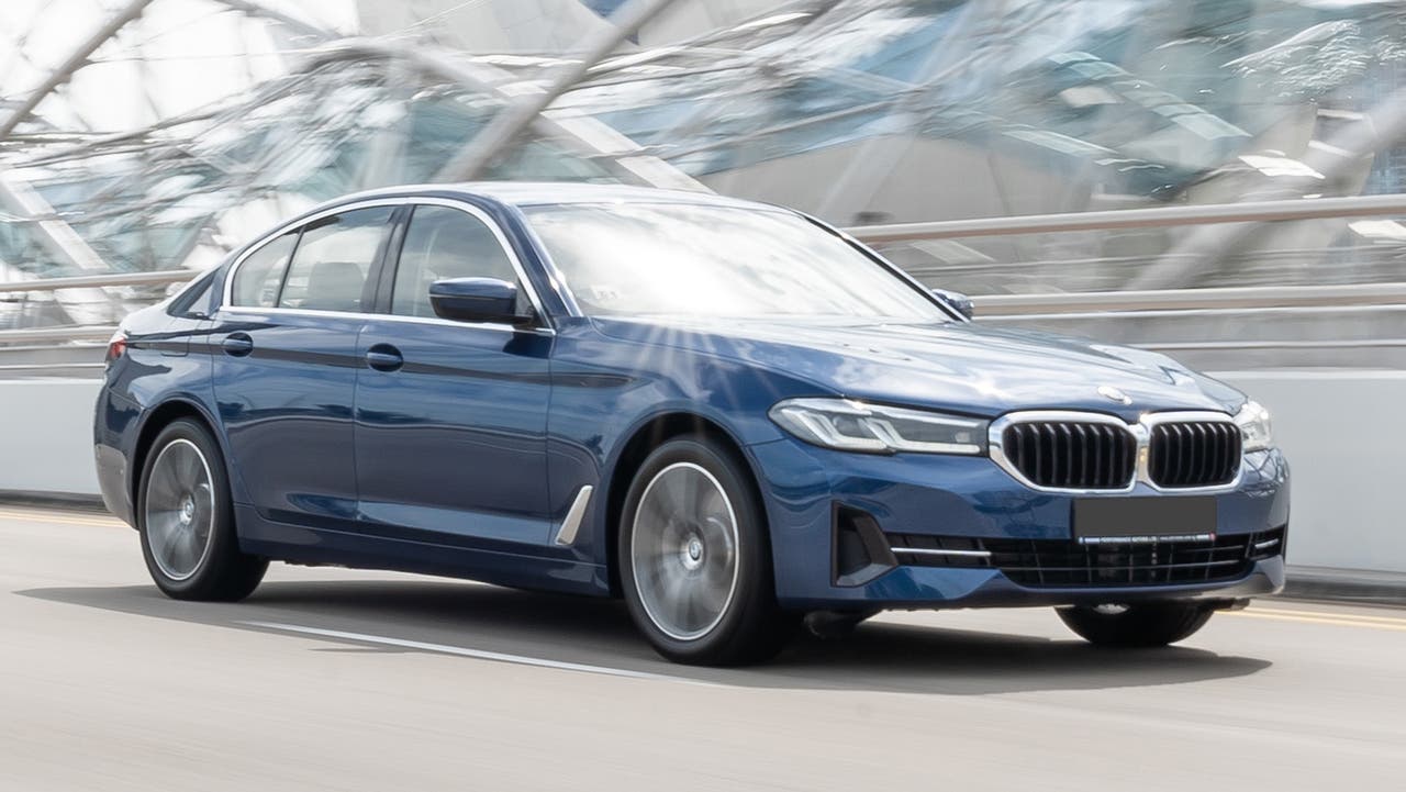 BMW 5 Series in blue, driving shot