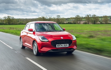 2025 suzuki swift red driving front three quarters
