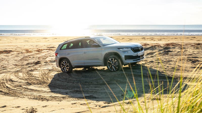 Skoda Kodiaq in grey, being driven on a beach by a person who is, presumably, impressed by the abundant head and legroom