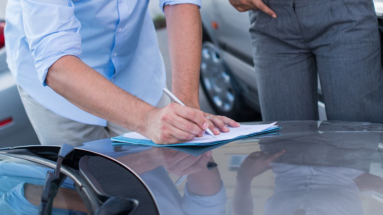 Car buyer writing down details