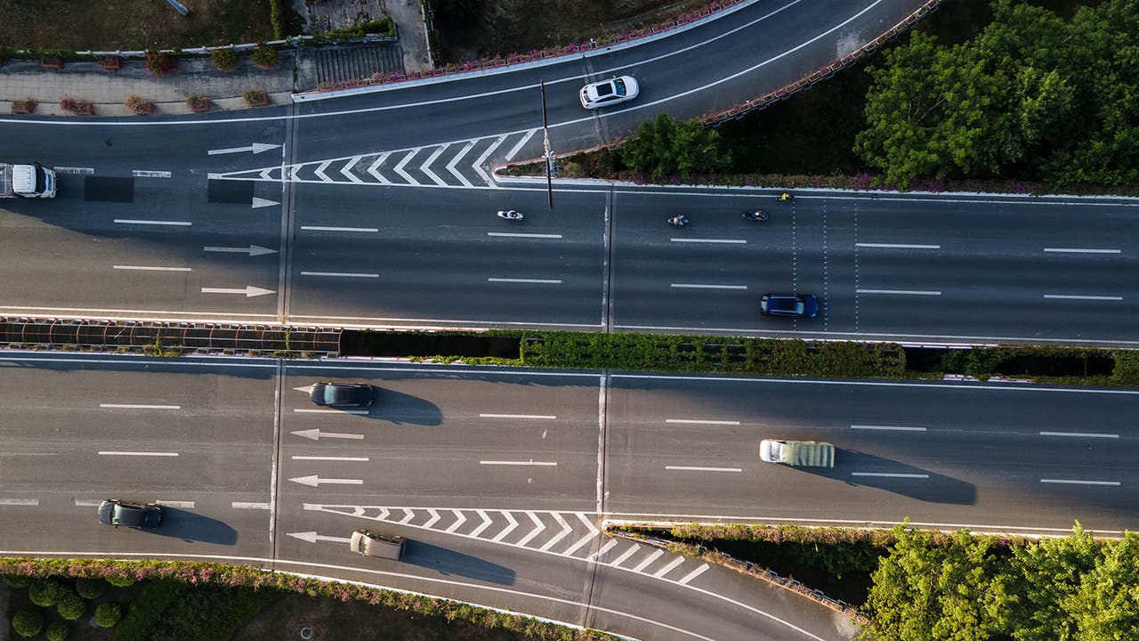 Top-down shot of a motorway with traffic leaving on one side and joining on the other