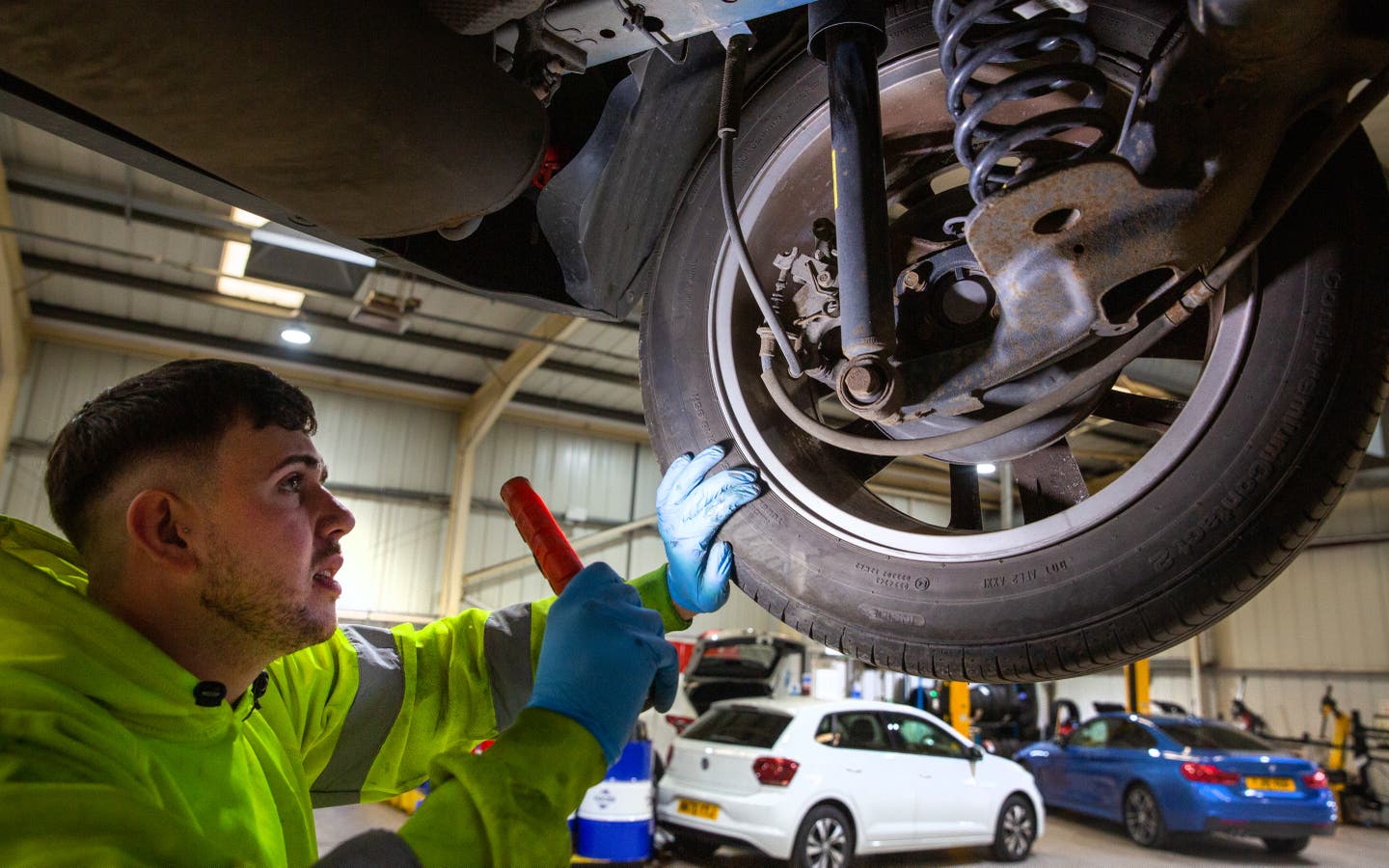 mechanic checking under side of car