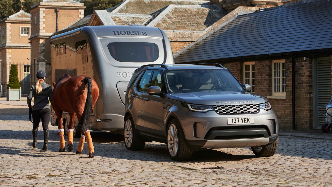 Land Rover Discovery pulling horsebox with horse nearby
