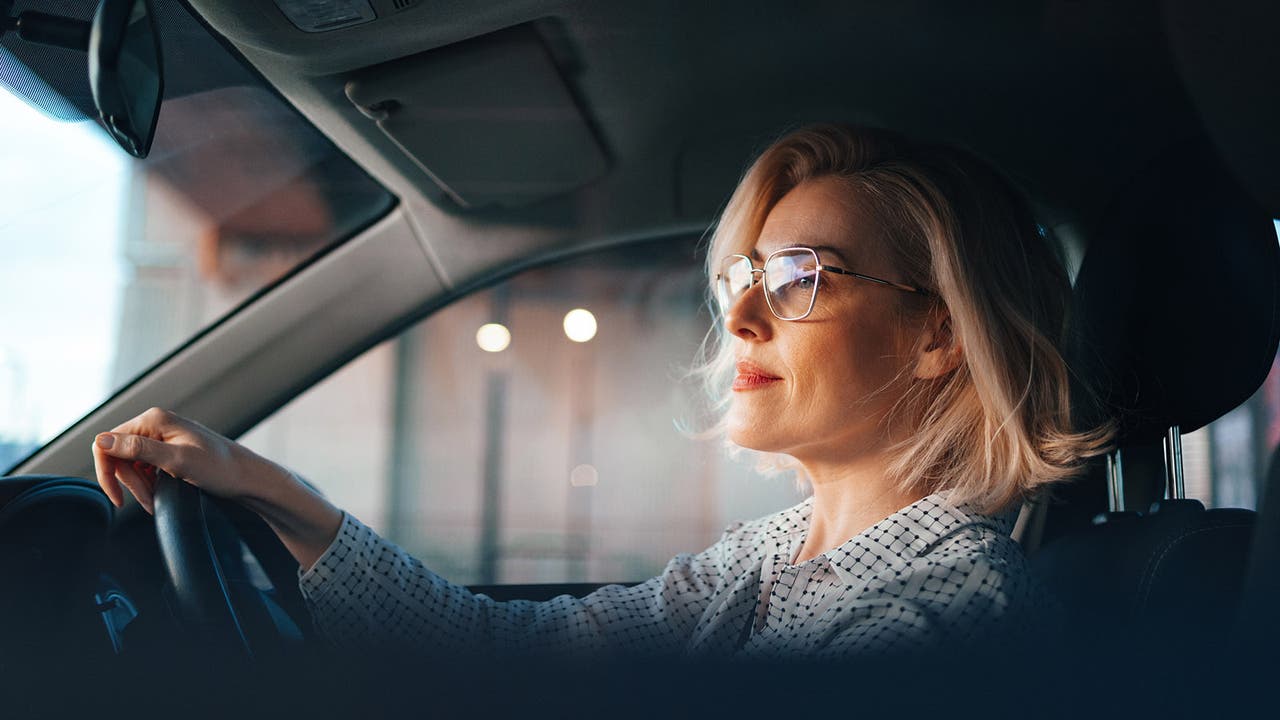 Lady driving car, looking pensive