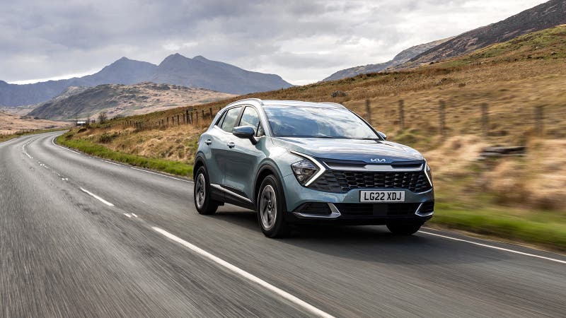 Grey Kia Sportage being driven down a scenic road, probably in Scotland