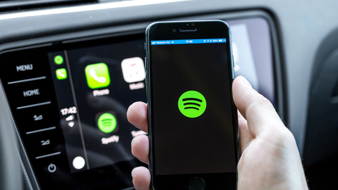 Spotify being used on a smartphone and car infotainment system