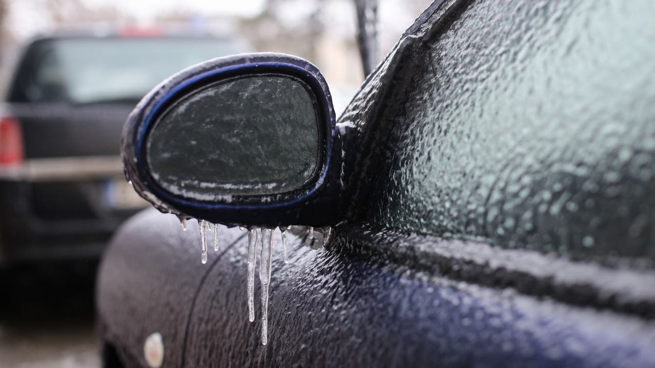 A car with a frozen window and wing mirror